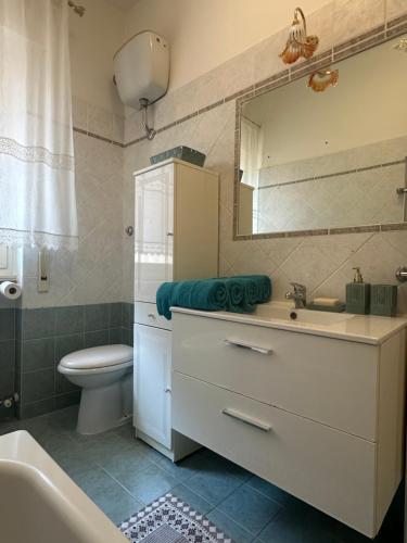 a bathroom with a sink and a toilet and a mirror at Casa Liliana in Ladispoli