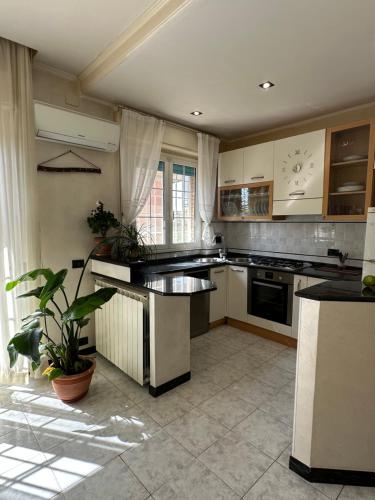 a kitchen with white cabinets and black counter tops at Casa Liliana in Ladispoli