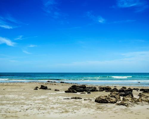 - une plage avec des rochers sur le sable et l'océan dans l'établissement Nouveau T2 Horizon Vue Mer Palavas, à Palavas-les-Flots