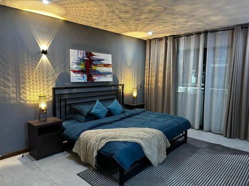 a bedroom with a blue bed and a window at PLSA Lovely Three Bedroom Home in Accra