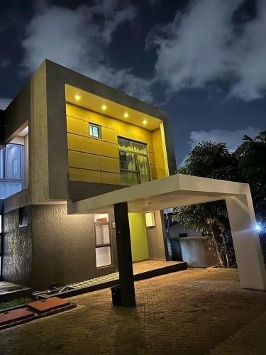 a large yellow building with a lit up front at PLSA Lovely Three Bedroom Home in Accra