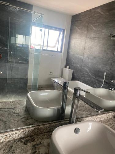 a bathroom with a sink and a mirror at PLSA Lovely Three Bedroom Home in Accra