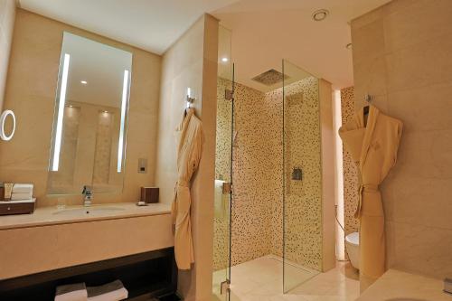 a bathroom with a shower and a sink and a toilet at Shaza Doha in Doha