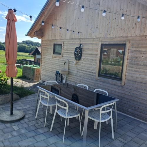 a patio with a table and chairs and an umbrella at Apartments Bukor with seasonal pool in Lukovica pri Domžalah