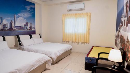 a small room with two beds and a window at 伊那部海景民宿 Inapu Ocean View B&B in Lanyu