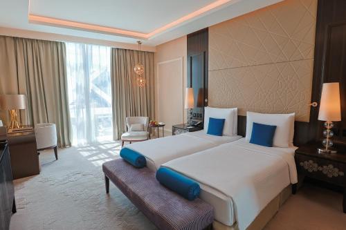a bedroom with a large bed and a large window at Shaza Doha in Doha