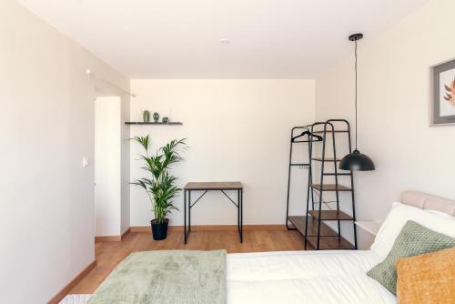 a living room with a bed and a table at L'essentiel, calme et climatisé - Accès autonome in La Ferté-Gaucher