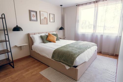 a bedroom with a large bed and a window at L'essentiel, calme et climatisé - Accès autonome in La Ferté-Gaucher