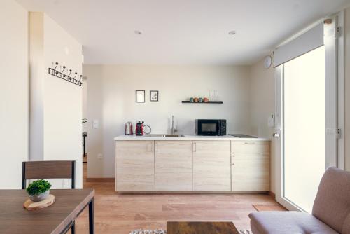 a kitchen with white cabinets and a table at L'essentiel, calme et climatisé - Accès autonome in La Ferté-Gaucher