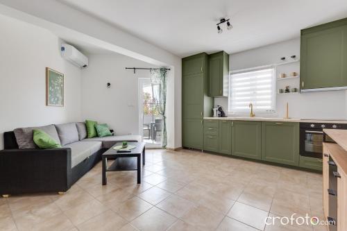 a living room with a couch and a kitchen at Apartmani Summer in Kolan