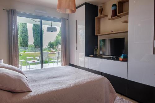 - une chambre avec un lit et une vue sur une terrasse dans l'établissement Rez de jardin d'exception sur les hauteurs de Nice, à Nice