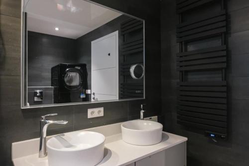 une salle de bain avec deux lavabos et un grand miroir dans l'établissement Rez de jardin d'exception sur les hauteurs de Nice, à Nice