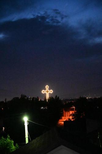 a cross on top of a building at night at Apartmani P7 in Dračevo