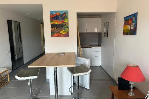 une cuisine avec une table et deux tabourets dans l'établissement Attractive T2 apartment - right in the city center, à Toulouse