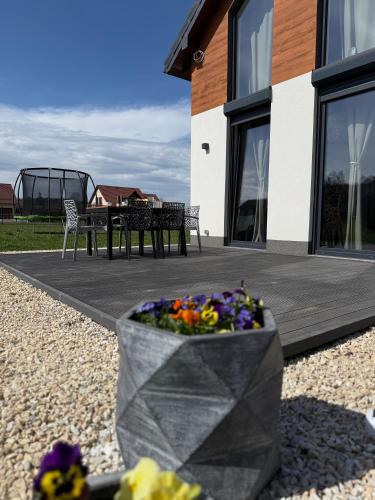 a planter with flowers in front of a house at Makówka in Mysłakowice