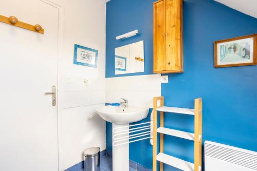 a bathroom with a sink and a blue wall at La maison à Landebec in Fouesnant