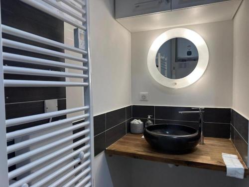 une salle de bain avec un lavabo noir et un miroir dans l'établissement Loft industriel en centre ville, au Puy-en-Velay