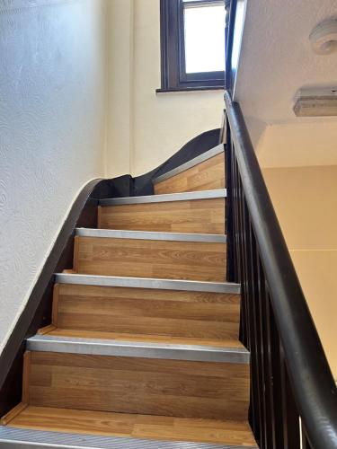 a staircase in a house with wooden floors and a window at La Gaffe - Bed and Breakfast in London