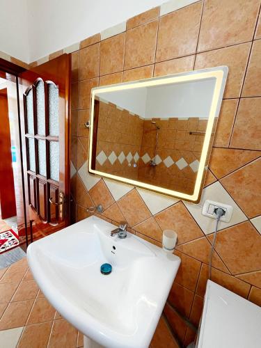 a bathroom with a white sink and a mirror at Green home in Durrës