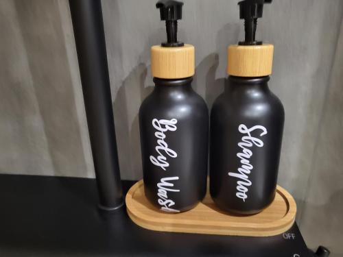 two black plastic bottles with white writing on them at Old town Bol rooms in Bol