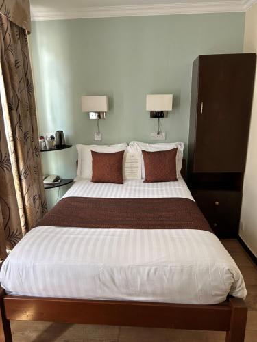 a large bed in a room with two lamps at La Gaffe - Bed and Breakfast in London