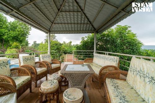 an outdoor patio with wicker chairs and a table at StayVista at Bayleaf Villa with Pool, Lawn, Wi-Fi in Nashik