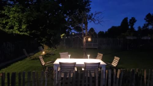 a table and chairs in a yard at night at PINE COTTAGE- 5 minutes Francorchamps - charme -piscine-calme-jardin in Sart