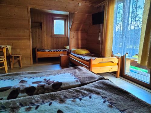 a bedroom with two beds and a tv in it at Ośrodek Wczasowy U Góralki in Murzasichle