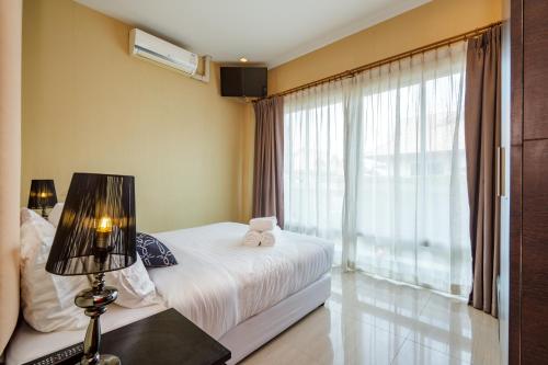 a bedroom with a bed and a large window at The Ville Jomtien Pool Villa in Jomtien Beach