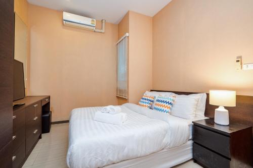a bedroom with a bed and a dresser and a television at The Ville Jomtien Pool Villa in Jomtien Beach