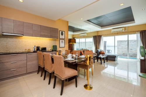 eine Küche und ein Esszimmer mit Tisch und Stühlen in der Unterkunft The Ville Jomtien Pool Villa in Jomtien Beach