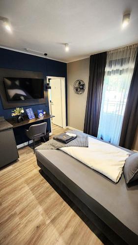 a bedroom with a large bed and a desk at Neueröffnung Liro Hotel Mönchengladbach in Mönchengladbach