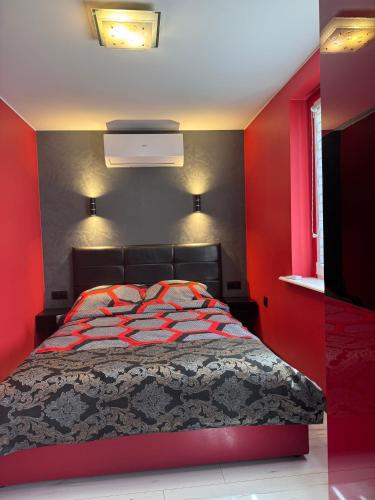 a red bedroom with a bed with a red wall at Migor Apartamenty in Łeba