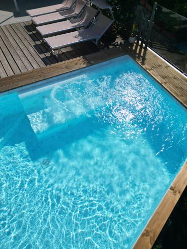 a large blue swimming pool with chairs in it at Villa Walter in Sorrento