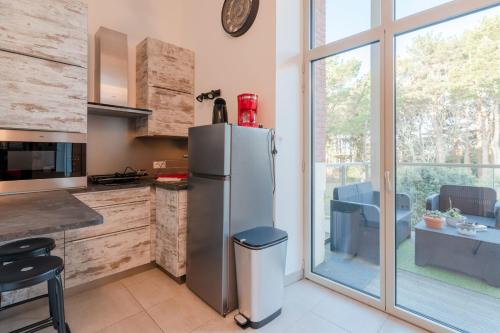 eine Küche mit Edelstahlkühlschrank und Fenster in der Unterkunft L'Albissia - 100m mer - Parking - Wifi in Pornic