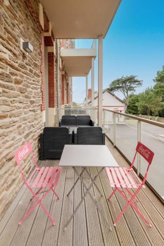 deux chaises roses et une table blanche sur une terrasse dans l'établissement L'Albissia - T2ParkingWifi, à Pornic