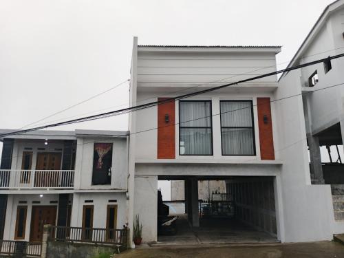 a white house with a lot of windows at Titik Senja Vila Dieng in Dieng