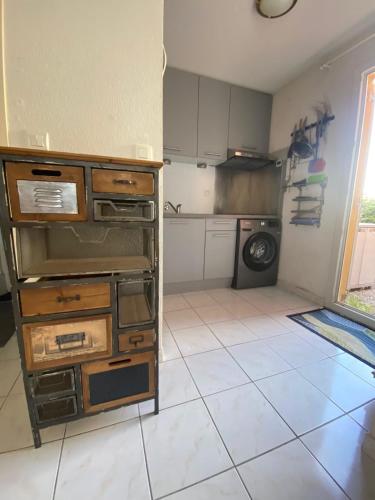une cuisine avec un évier et une machine à laver dans l'établissement Marine Wave, à Aresquies