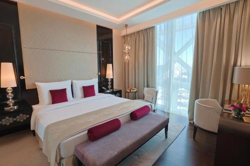 a large bedroom with a large bed with red pillows at Shaza Doha in Doha