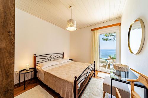a bedroom with a bed and a view of the ocean at Apartments Bisko in Prizba