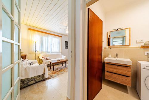 a bathroom with a sink and a room with a couch at Apartments Bisko in Prizba