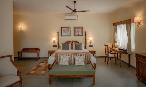 a bedroom with a bed and a desk at Aloof Jungle Lodge in Ghānerao