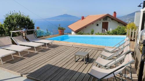 a wooden deck with chairs and a swimming pool at Villa Walter in Sorrento