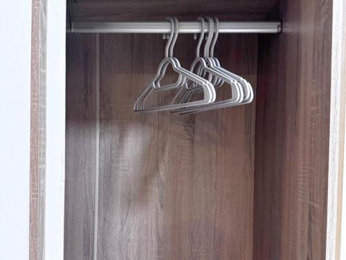 a closet with three hangers on a wooden door at Maesai Bliss Residence in Ban Pa Yang