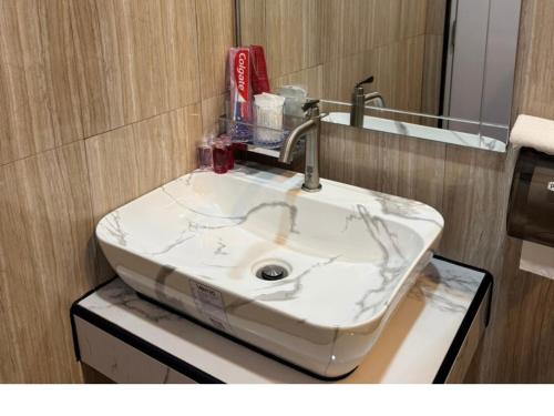 a bathroom with a white sink and a mirror at Maesai Bliss Residence in Ban Pa Yang