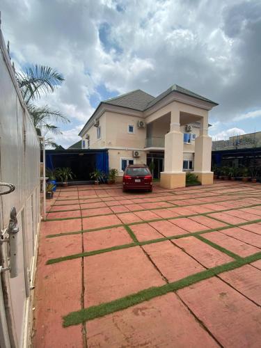 a house with a red car parked in a driveway at Christees Lodge Limited in Mama