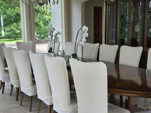 a dining room with a table and white chairs at Lakeside Grande Villa in Alexander City