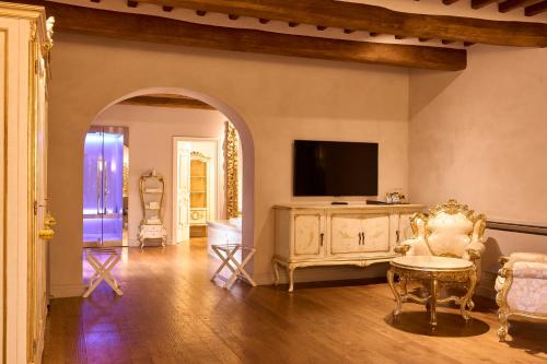 a living room with a tv on a wall at Relais La Corte dei Papi in Cortona