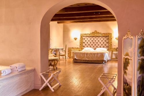 a bedroom with a bed in a room with an archway at Relais La Corte dei Papi in Cortona