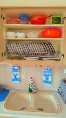 a kitchen sink with dishes on a shelf above it at Francesco's Apartment-Chalkidiki in Flogita